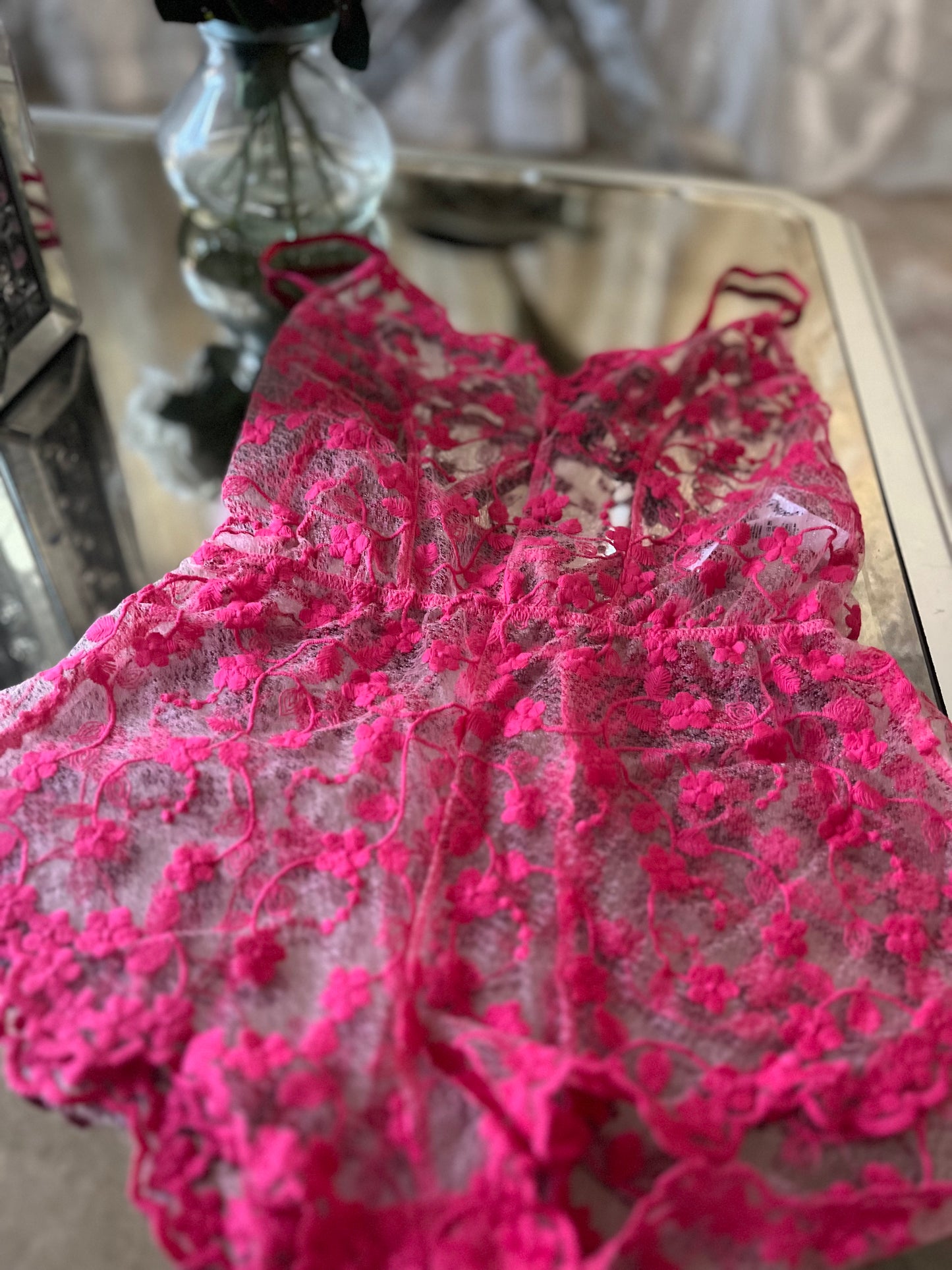 Close up of embroidered floral lace on cherry sleep romper