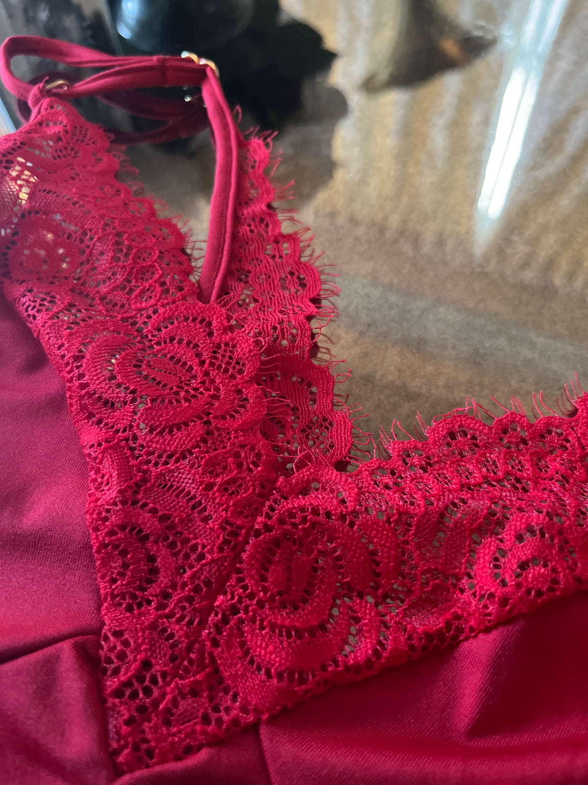 Close up of eyelash lace trim on red chemise bust