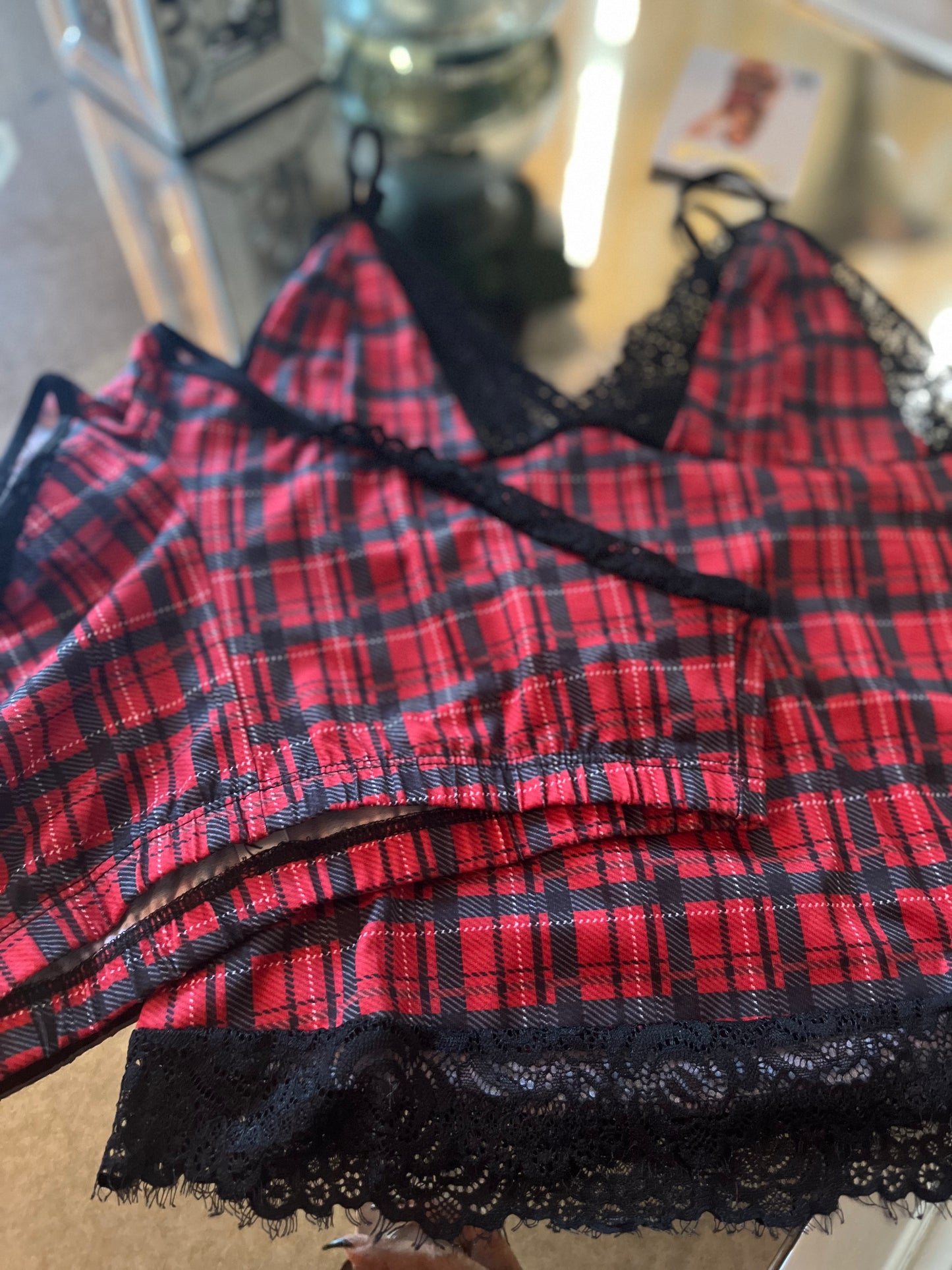 Close up of black lace trim on red plaid cami top