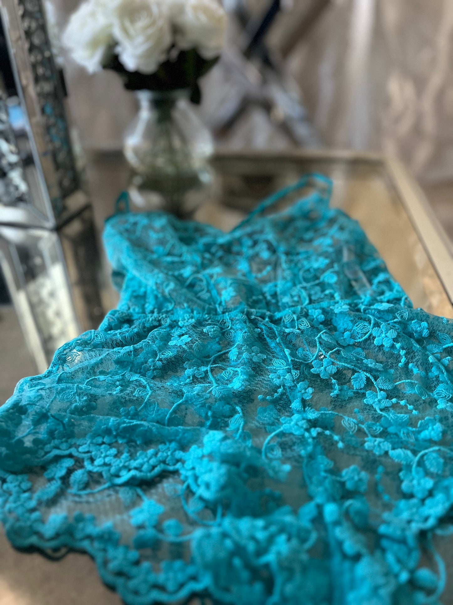 Model wearing turquoise embroidered lace sleep romper
